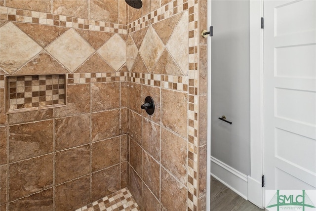 details with hardwood / wood-style floors and tiled shower