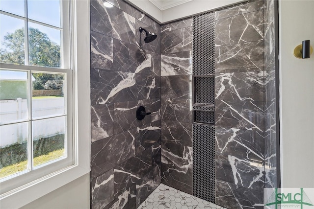 bathroom with ornamental molding, plenty of natural light, and a tile shower