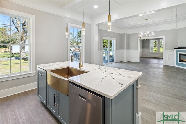 kitchen featuring a kitchen island with sink, dark hardwood / wood-style flooring, pendant lighting, gray cabinets, and dishwasher