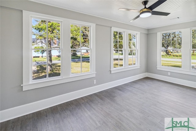 unfurnished sunroom featuring ceiling fan and plenty of natural light