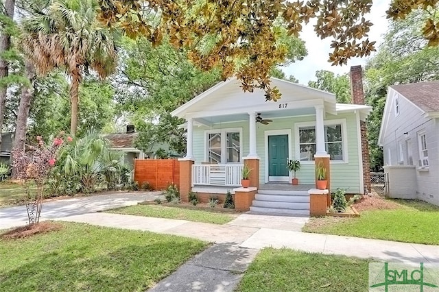 bungalow-style house featuring ceiling fan, a front yard, and covered porch