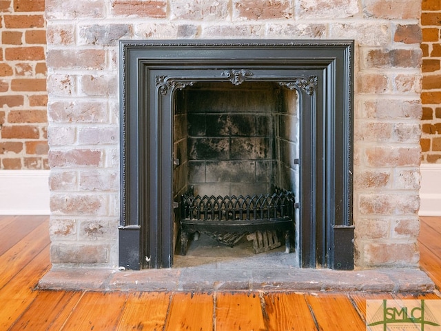 details featuring a brick fireplace and hardwood / wood-style floors