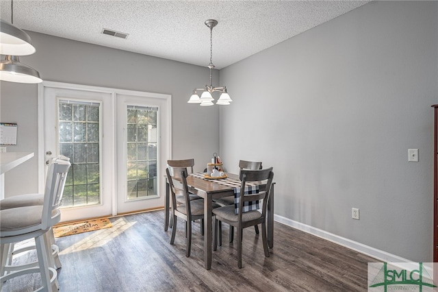 dining room with french doors, dark hardwood / wood-style flooring, and a textured ceiling