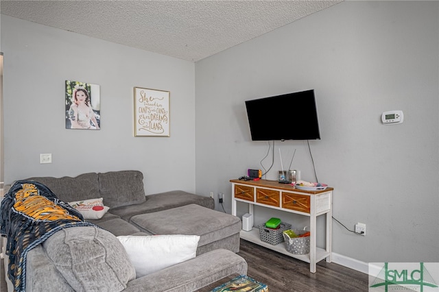 living room featuring a textured ceiling and dark hardwood / wood-style flooring