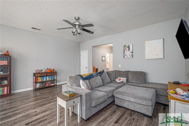 living room with ceiling fan, dark wood-type flooring, and a textured ceiling