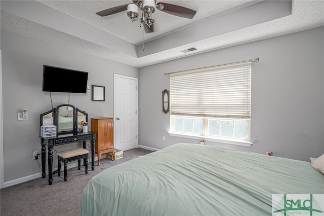 carpeted bedroom with ceiling fan and a textured ceiling