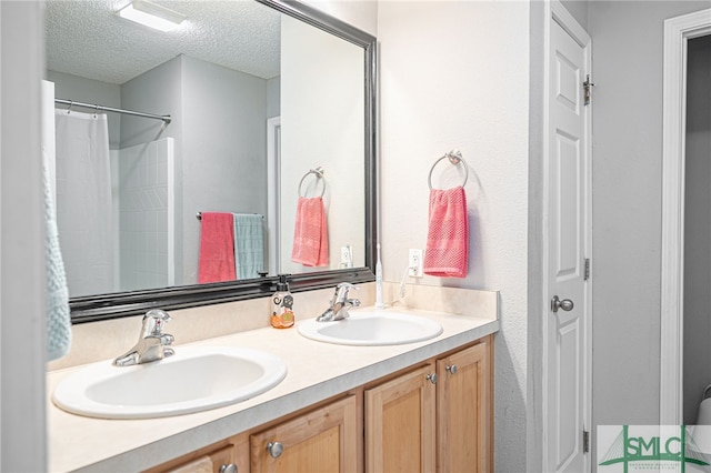 bathroom with vanity, a shower with shower curtain, and a textured ceiling