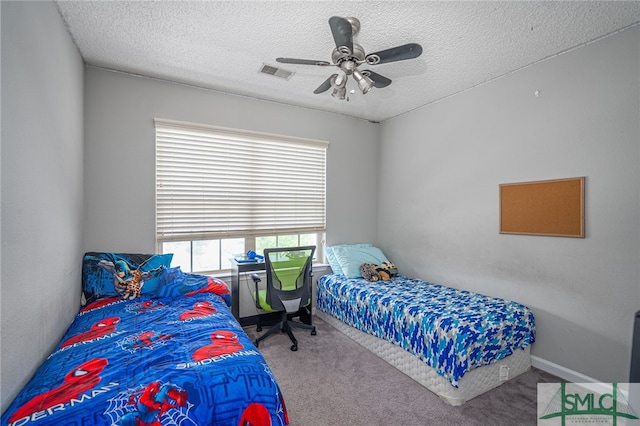 bedroom featuring ceiling fan, a textured ceiling, and carpet flooring