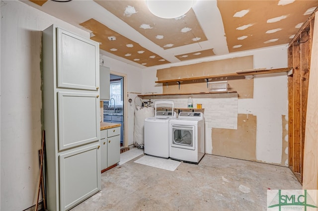 laundry room featuring washer and clothes dryer, a sink, and cabinet space