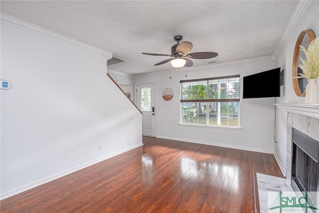 unfurnished living room featuring ceiling fan, a textured ceiling, ornamental molding, dark hardwood / wood-style floors, and a tile fireplace