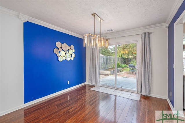 unfurnished dining area featuring hardwood / wood-style floors, crown molding, a notable chandelier, and a textured ceiling