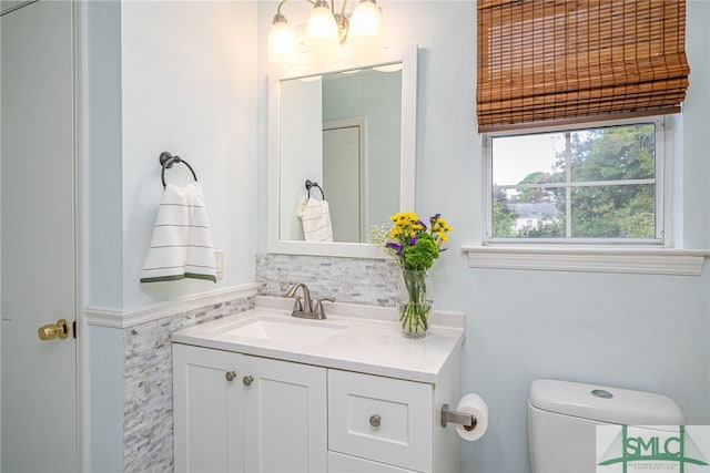 bathroom featuring backsplash, vanity, and toilet