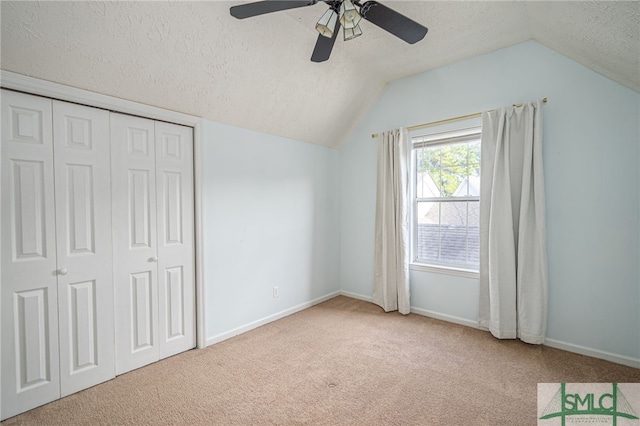 unfurnished bedroom with light carpet, vaulted ceiling, and ceiling fan