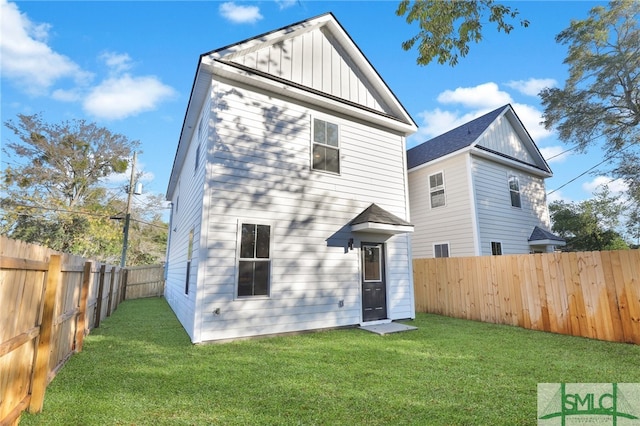 rear view of property with a lawn