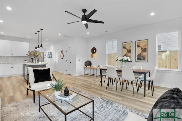 living room featuring ceiling fan and light wood-type flooring