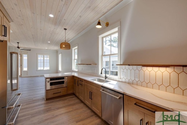 kitchen with tasteful backsplash, stainless steel appliances, sink, decorative light fixtures, and wooden ceiling