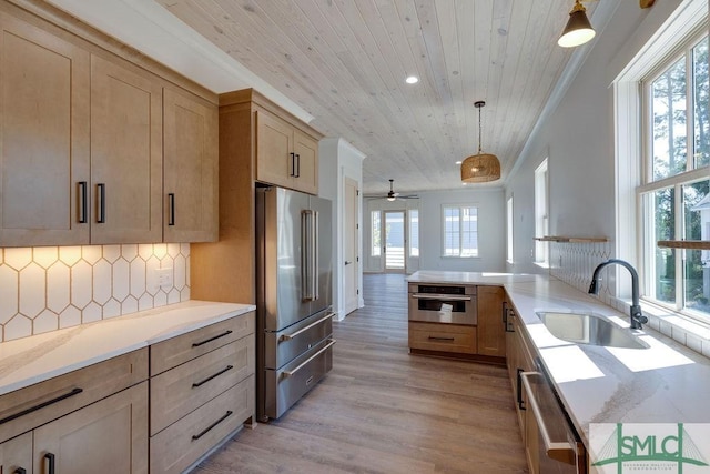 kitchen featuring kitchen peninsula, plenty of natural light, hanging light fixtures, and appliances with stainless steel finishes