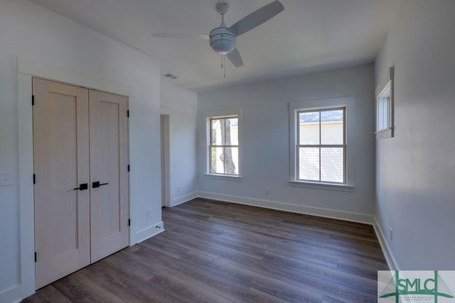 unfurnished bedroom featuring ceiling fan, a closet, and dark wood-type flooring