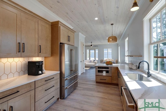 kitchen featuring a wealth of natural light, pendant lighting, and appliances with stainless steel finishes