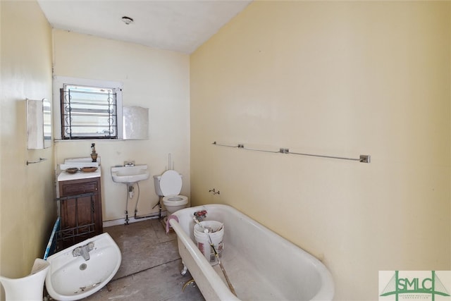 bathroom with toilet, a bathing tub, concrete flooring, a bidet, and vanity