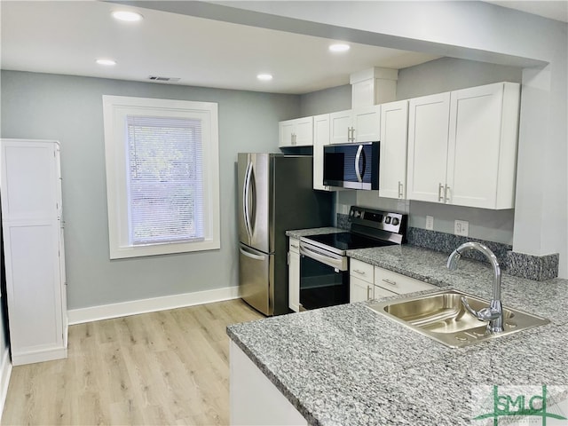 kitchen with white cabinetry, light hardwood / wood-style flooring, stainless steel appliances, and sink