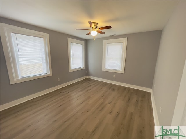 unfurnished room with ceiling fan and dark hardwood / wood-style flooring