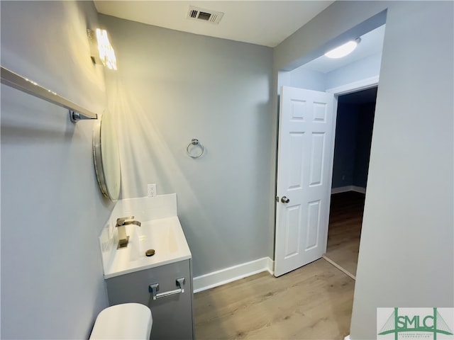 bathroom featuring vanity, toilet, and wood-type flooring