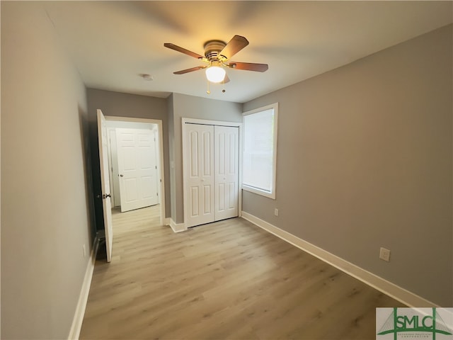 unfurnished bedroom featuring light hardwood / wood-style flooring, a closet, and ceiling fan