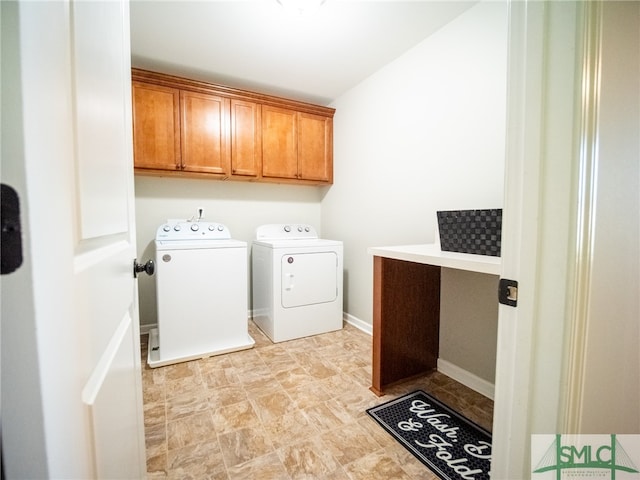 clothes washing area with washing machine and clothes dryer and cabinets