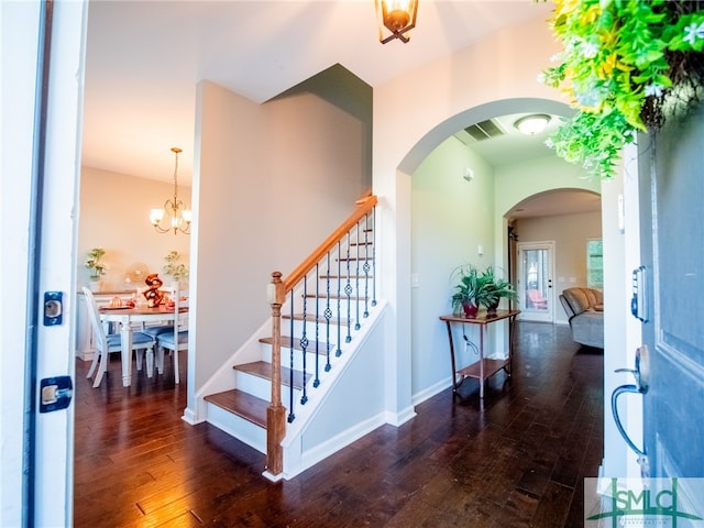 foyer entrance featuring dark hardwood / wood-style floors and a chandelier