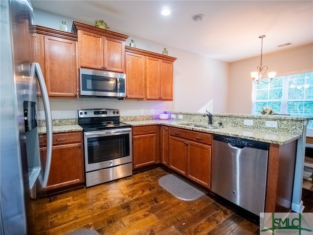 kitchen with sink, appliances with stainless steel finishes, dark hardwood / wood-style flooring, kitchen peninsula, and a chandelier