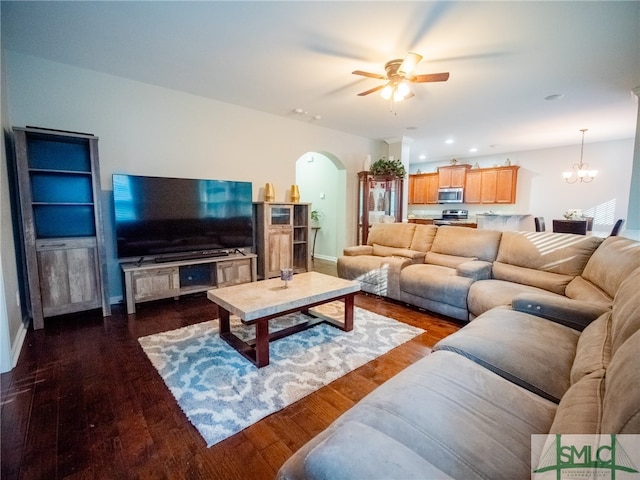 living room with ceiling fan with notable chandelier and dark hardwood / wood-style floors