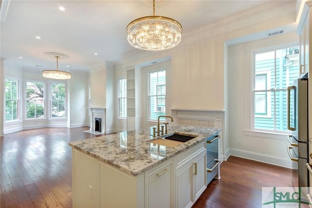 kitchen featuring a wealth of natural light, sink, and hanging light fixtures