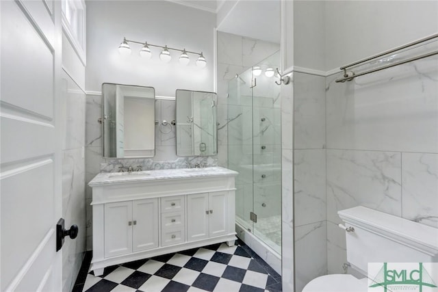 bathroom featuring a shower with door, vanity, tile walls, and toilet