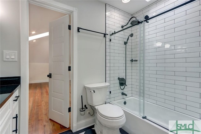 full bathroom with hardwood / wood-style floors, vanity, toilet, and enclosed tub / shower combo