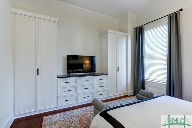 bedroom with dark hardwood / wood-style floors and crown molding