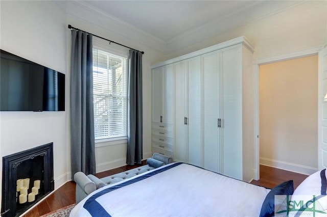 bedroom with dark hardwood / wood-style floors and ornamental molding