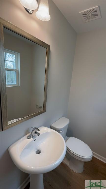 20 Flagler Dr, Savannah, GA 31419 - half bath featuring a sink, toilet, visible vents, baseboards, and wood finished floors