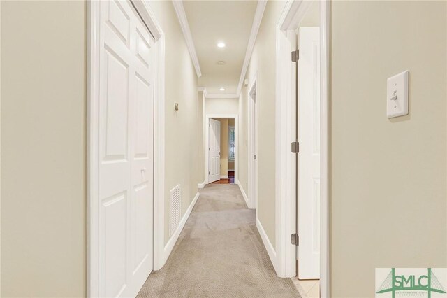 corridor featuring light colored carpet and crown molding