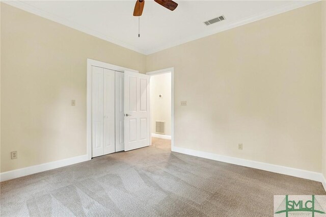 carpeted empty room featuring ceiling fan and ornamental molding