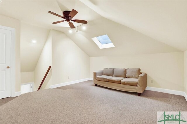 interior space featuring ceiling fan, lofted ceiling with skylight, and carpet floors