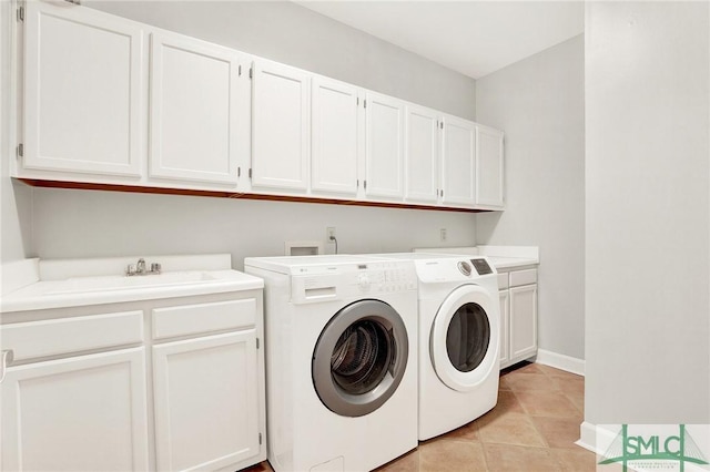 washroom with sink, light tile patterned floors, cabinets, and independent washer and dryer