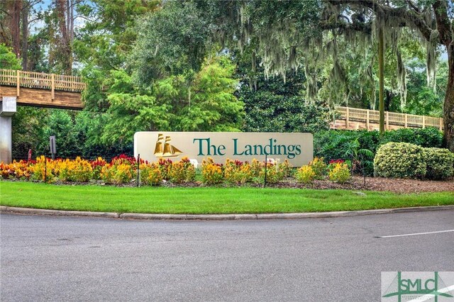 community / neighborhood sign featuring a yard