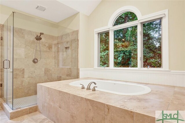 bathroom featuring separate shower and tub and vaulted ceiling