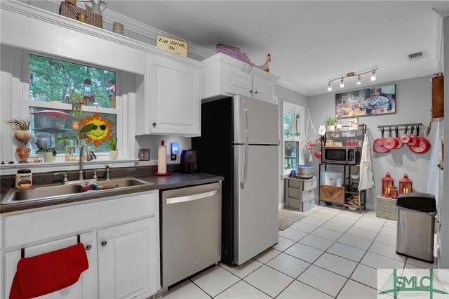 15 Cromwell Pl, Savannah, GA 31410 - kitchen featuring appliances with stainless steel finishes, a sink, dark countertops, light tile patterned floors, and white cabinets