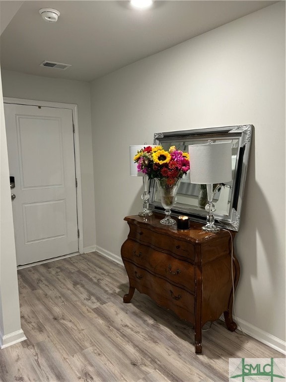 corridor with light hardwood / wood-style floors