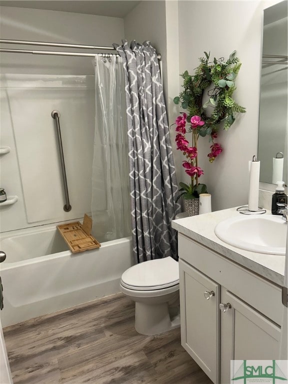 full bathroom with wood-type flooring, shower / bath combo, vanity, and toilet