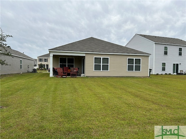 rear view of house featuring a yard