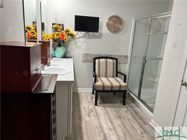 bathroom featuring hardwood / wood-style flooring, a shower with door, and vanity