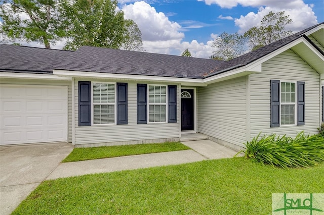 ranch-style home featuring a garage and a front lawn